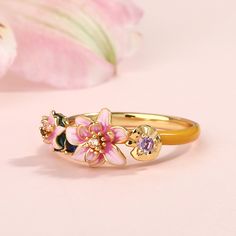 Transforming the iconic "Water Lilies" from Monet into an unexpected and artistic treasure, this beautifully detailed ring boasts charming lotuses in bright shades of enamel. The intricate flawless enamel work coupled with sparking stones, make this an eye-catching piece. Encapsulating peace and harmony, this intricately crafted ring looks beautiful worn alone or when layered in a stack. The stacking ring showcases the dreamlike play of light and shadow on the shimmering water surface. In Monet' Elegant Pink Enamel Ring, Delicate Pink Flower Ring For Wedding, Elegant Gold Enamel Flower Ring, Elegant Adjustable Pink Flower Ring, Pink Flower Enamel Ring For Gift, Pink Flower Ring Fine Jewelry, Pink Flower Enamel Ring For Wedding, Pink Round Enamel Wedding Ring, Pink Enamel Round Ring For Wedding