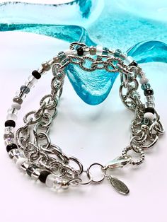 "Triple Strand Bracelet Featuring Antique Silver Plated Chain and Miyuki Glass Beads.  * 7.75\" Long  * Textured 7x9mm Chunky Oval Link Chain * Smooth 7x9mm Chunky Oval Link Chain  * Miyuki Glass Beads in Various Color Choices  * SEE PICTURES 9 & 10 for Color Choices in Drop Down Menu  * Note regarding sizing: As this bracelet has three strands it takes up more space/reduces the circumference.  For reference I have a 6.25\" wrist and this 7.75\" bracelet fits me comfortably to loose.  This and all other items in my shop are handmade by me in the great state of Delaware! Please see my Shop Announcement for additional important information before placing your order. Thank you!" Beaded Multi-strand Metal Bracelets, Silver Beaded Chain Charm Bracelet Gift, Silver Bracelet With Beaded Chain For Gift, Elegant Multi-strand Silver Beads Bracelet, White Chain Bracelet For Party, Adjustable Beaded Chain Bracelet, Silver Wrap Bracelet With Faceted Beads, Elegant Silver Wrap Bracelet With Faceted Beads, Metal Bracelets With Adjustable Chain And Round Beads