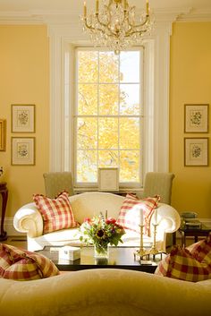 a living room filled with furniture and a chandelier hanging from the ceiling next to a window