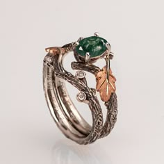 "A handmade 14k twig and leaf ring made in two gold colors and set with a natural, high-quality moss agate of your choosing and three small diamonds. The grooves in the band are plated with black rhodium which emphasizes the texture. if you prefer not to apply the black rhodium that is fine. I can also use white, rose or yellow gold for the band and the leaves for the same price. The ring in the pictures is set with a 7mmX5mm oval-shaped moss agate but can be set with any other stone, please contact me for a quote. If you are looking at this ring then you are probably looking for something special, something different. The engagement rings I design are made of 100% recycled gold and non-conflict diamonds of high quality. After I am sure you have seen a huge variety of engagement rings I am Twig Engagement Ring, Cute Engagement Rings, Moss Agate Ring, Gold Colors, Oak Leaf, Leaf Ring, Agate Ring, Fancy Jewelry, Pretty Rings