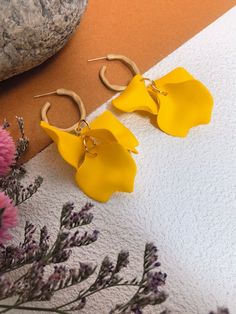 🌟 Indulge in the sophistication of the Yellow Floral Petal Huggie Hoop Earrings. Delicate yellow acrylic floral petals adorn these exquisite women's jewelry pieces, adding a touch of elegant beauty to any ensemble. Perfect for any occasion, these huggie hoop earrings are a must-have for any stylish and exclusive wardrobe. * 2 3/4" (66mm) drop * 1" (30mm) width * Post back * Acrylic/alloy/925 silver needle * 14k-gold plate 🌟 Helpful info: Protect your precious jewelry by keeping it away from wa Elegant Beauty, Chic Earrings, Statement Drop Earrings, Huggie Hoop Earrings, Etsy Earrings Dangle, Precious Jewelry, Yellow Floral, Statement Earrings, Favorite Jewelry