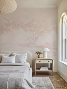 a bedroom with pink wallpaper and white bedding in front of a large window