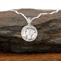 Introducing our exquisite Custom Date Dime Necklace, a perfect treasure to commemorate your loved one's special moments! Whether it's a birthday, anniversary, or any other occasion, this unique piece makes an extraordinary gift that will be cherished forever. Features and Details: - Adorned with an 18 inch sterling silver-plated curb chain, this necklace exudes elegance and is designed to be comfortably worn every day. - The dime is bezel mounted, ensuring lasting protection while enhancing the beauty of the coin. - Each necklace is exclusively made to order, allowing you to create a truly personalized keepsake. Select the memorable year of any significant event. Capturing those precious memories has never been easier! We truly understand the importance of unforgettable moments. This Custo Anniversary Coin Pendant Charm Necklaces, Nickel-free Necklace For Anniversary, Anniversary Charm Necklace With Coin Pendant, Nickel-free Round Necklace For Anniversary, Nickel Free Necklace For Anniversary, Anniversary Coin Pendant Jewelry, Anniversary Gift Coin Pendant Jewelry, Classic White Gold Charm Necklaces For Anniversary, Classic White Gold Charm Necklace For Anniversary