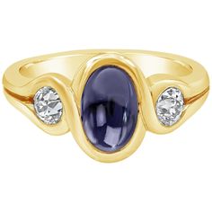 A appealing gemstone fashion ring showcasing a 2.50 carat oval shape blue sapphire cabochon in the center and an old european cut diamond on each side weighing 0.80 carats total. Set in an integrated bezel, Made in 18K Yellow Gold, Size 7.5 US Style available in different price ranges. Prices are based on your selection. Please contact us for more information.