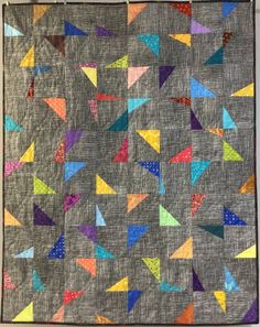 a quilt with many different colored triangles on it