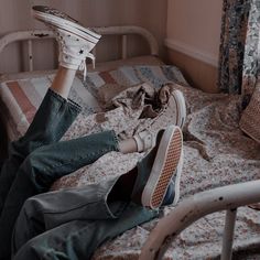 a person laying on top of a bed with their feet propped up in the air