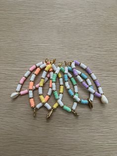 multicolored beaded bracelets on wooden table with gold earring hooks and chain