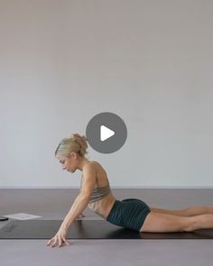 a woman is laying on the floor doing yoga