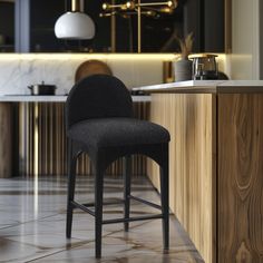 a black chair sitting in front of a counter top next to a wooden bar stool