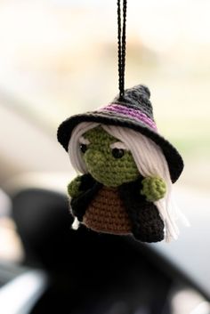 a crocheted ornament with a hat and scarf on it's head