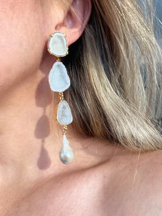 Edith earrings are a showstopper! They feature white geode posts set in gold with cascading geodes in shades of white and a single cream keshi pearl on each side. They are stunning and still lightweight. We hand select the most beautiful stones that are also on the thinner side to keep them comfortable for the ear. These are a favorite among brides! Approximately 4.5” in length. Please note each pair will differ slightly as no two stones are ever exactly the same. Luxury White Earrings With Gemstone Accents, White Pearl Earrings With Natural Stones, Unique White Pearl Earrings For Wedding, Luxury White Linear Earrings Gift, White Drop Pearl Earrings With Natural Stones, White Gemstone Drop Earrings, Elegant White Earrings With Gemstone Accents, Elegant Gold Linear Earrings With Natural Stones, White Natural Stone Pearl Earrings For Wedding