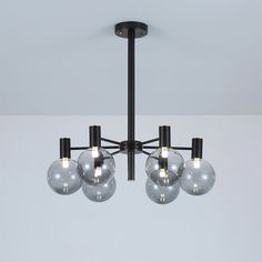 a chandelier with five clear glass balls hanging from it's black frame