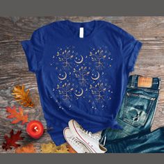 Enjoy our celestial moon and stars t-shirt.  Bella + Canvas style 3001 T-Shirt: 🍁popular unisex style 🍁eco friendly  🍁known for its durability FIT: 🍁the fit is more narrow than a traditional men's cut, but not as fitted as women's tee. 🍁Customers should order true to size for a more fitted look and size up for a looser fit.  ⭐️See size chart in photos ⭐️Rolled up sleeves are for style purposes  T-SHIRT MATERIALS 🍁Solid colors: 100% airlume combed and ring-spun cotton 🍁Heather colors: 52% Relaxed Fit Short Sleeve T-shirt With Moon Print, Blue Star Print Graphic Tee, Blue Graphic Tee With Star Print, Celestial Style Cotton Crew Neck Tops, Celestial Moon Print Crew Neck T-shirt, Celestial Cotton T-shirt With Crew Neck, Celestial Short Sleeve Cotton Tops, Celestial Short Sleeve Tops With Moon Print, Celestial Style Graphic T-shirt For Summer