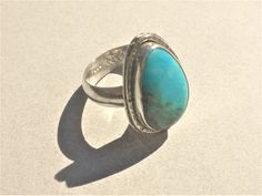 This ring features a lovely vivid blue Kingman Turquoise with a bit of olive-green Matrix. The stone is cut into a freeform teardrop and softly polished.   I set the Turquoise into fine silver onto a sterling silver; a hammered wire surrounds the setting and adds sparkle. Size of the Turquoise is about 18 x 11 x 4 mm. The 5 mm wide ring band is domed and very comfortable.  Ring size is 7 1/2. Resizing is not available. Southwestern Blue Turquoise Teardrop Ring, Handmade Blue Turquoise Teardrop Ring, Handmade Turquoise Teardrop Ring, Handmade Teardrop Turquoise Ring, Southwestern Blue Teardrop Ring, Southwestern Teardrop Blue Rings, Bohemian Blue Teardrop Ring, Blue Cabochon Teardrop Ring, Blue Teardrop Cabochon Rings