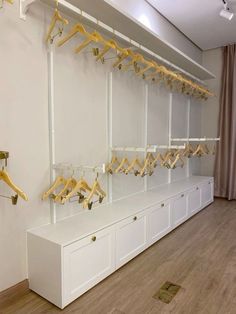 a room with white cabinets and yellow hangers