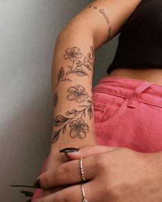 a woman with a flower tattoo on her arm