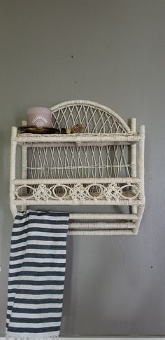 a white shelf with a blue and white towel hanging on it