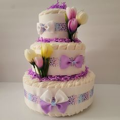 a three tiered cake decorated with purple and white flowers