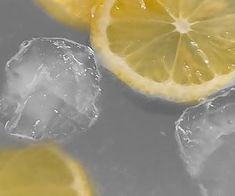 three lemons and ice cubes are shown in this close up photo, with one cut in half