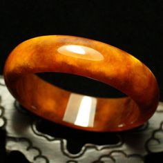 59mm Golden Yellow and White Clouds Hand-carved Natural Jade Bangle #A3 weight: 76.5g, 421.5 Ct Jade NameNatural Jade Item SizeInner diameter: 58 mm Width:17.6mm Thickness: 7.1 mm This unique bangle has lots of internal feature with clouds, silk streaks and wen. Inviting autumn color with this golden orange tawny with white flowers. This is a gorgeous and high quality jadeite bangle. Luxury Collectible Round Bangle, Luxury Round Amber Jewelry, Luxury Carved Bracelet Jewelry, Collectible Carved Round Jewelry, Handmade Luxury Bangle For Formal Occasions, Luxury Handmade Bangle For Formal Occasions, Elegant Brown Bangle For Formal Occasions, Luxury Engraved Round Bangle, Elegant Formal Brown Bangle