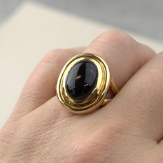 This bold, statement onyx ring is a timeless piece of jewelry. Crafted in 14K yellow gold, it features a polished oval cabochon stone that makes this piece stand out. Timeless Signet Ring With Oval Cabochon Gemstone, Luxury Oval Black Enamel Rings, Modern Yellow Gold Signet Ring With Cabochon, Timeless Onyx Signet Ring With Polished Finish, Timeless Yellow Gold Oval Cabochon Signet Ring, Modern Gold Signet Ring With Cabochon, Classic Oval Cabochon Dome Ring With Polished Finish, Timeless Oval Dome Ring For Formal Occasions, Elegant Oval Cabochon Gemstone Signet Ring