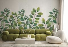 a living room with a green couch and wall mural