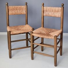 two wooden chairs sitting next to each other