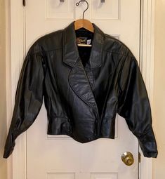 Gorgeous, heavy but soft, double-breasted, original from the 1980s black leather jacket. This jacket has the toughness of leather, but button it up and cinch that waist and its sleek too. This is old school leather - it makes noise when you move, it smells like leather, it's stiffer than modern leather jackets too. It's old and has creases and scuffs that make it look cool, but no issues. Woman's size medium. Feel free to ask questions. In need of more fun vintage? https://retroburgh.etsy.com Greaser Jacket, Vintage Black Leather Jacket, Studded Leather Jacket, Studded Jacket, Cropped Leather Jacket, Leather Jacket Black, Leather Motorcycle Jacket, Studded Leather, Black Leather Jacket