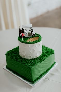 a golf themed cake on a table with white and green grass in the shape of a car