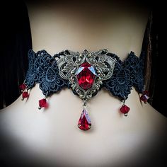 "This vintage gothic styled crystal choker necklace features captivating Siam Red Swarovski crystals with nice crisp facets and brass embellishments.  The detailed stampings have been in production since the 1940's and the vintage 16x11mm focal crystal is no longer in production, making this necklace a rare find.  The lace is double-layered and hand sewn together for extra durability. Both elegant and stylish, this piece would be perfect for any formal occasion. Swarovski Crystals are made in Austria and are the highest quality lead free glass-cut crystals on the market, with extra facets and gold foiling for outstanding brilliance and sparkle. The choker lace is 12.5\" long and includes a 3\"extension chain, totaling 15.5\" of length.  A pretty gold colored star hangs down from the chain Vampire Choker, Red Choker Necklace, Red Vampire, Red Choker, Lace Choker Necklace, Crystal Lace, Crystal Choker Necklace, Vintage Sapphire, Vintage Gothic