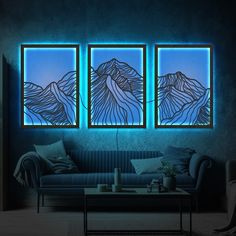 three paintings on the wall above a couch in a room with blue walls and furniture