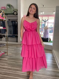 Let Elane's playful pleats charm you to sway with tiered ruffles! Don't miss the chance to twirl and whirl around in a flirty fuchsia that goes perfectly with a cheeky bow in front! Pink Ruffle Dress For Day Out, Pink Flirty Ruffle Dress For Day Out, Flirty Pink Ruffle Dress For Day Out, Flirty Tiered Skirt Ruffle Dress For Brunch, Flirty Tiered Ruffle Dress For Brunch, Pink Tiered Ruffle Dress With Layered Hem, Pink Tiered Dress With Ruffle Hem, Chic Pink Tiered Skirt Dress, Chic Pink Dress With Tiered Skirt