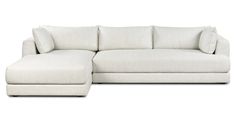 a white sectional couch with pillows on it's back and the seat folded out