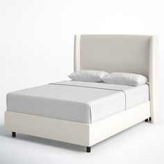 a bed with white sheets and pillows on it's headboard, sitting in front of a white wall