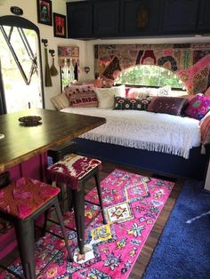 a room with a bed, desk and rugs on the floor in front of it