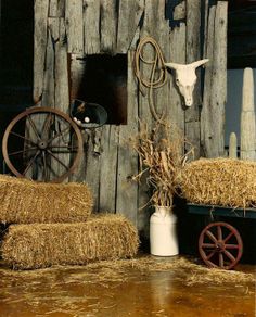 hay bales stacked on top of each other in front of a wooden wall with an animal head