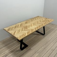 a wooden table sitting on top of a hard wood floor next to a white wall