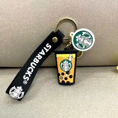 a starbucks keychain is sitting next to a yellow flower