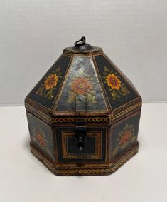 an old fashioned box with flowers painted on the inside and sides, sitting on a white surface