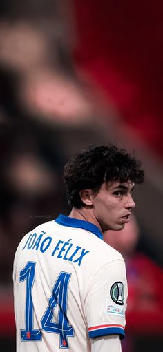 a soccer player is standing in front of the crowd with his head turned to the side