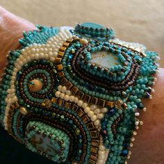 a close up of a person's wrist with beaded bracelets on it