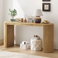 a table with a lamp, camera and other items on it in front of a white wall