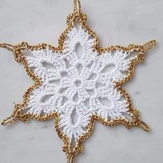 a gold and white crochet snowflake ornament