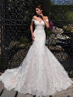 a woman in a wedding dress posing for the camera