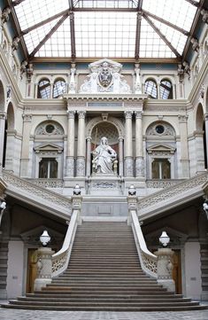 the inside of a building with stairs leading up and down to it's entrance