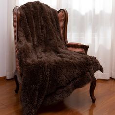 a chair with a blanket on it in front of a window