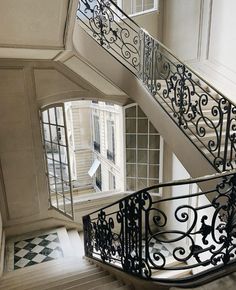 a staircase with wrought iron railings and windows