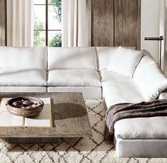 a living room with white couches and rugs