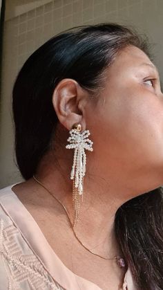 "Handmade statement Ivory pearl and gold chain floral long earrings. These handmade statement earrings are made of faux pearl flower, and electroplated rose gold chain fringes. The earrings are beautiful and ideal for weddings and parties. The earrings measures approx. 4\" long and 1\" wide. Carnation jewellery are purely handmade & handcrafted in India. Since our product is purely handmade in nature hence a slight imperfection may be there but it is almost negligible. The colors and may slightl Gold Tassel Earrings For Wedding, Elegant Wedding Tassel Earrings With Latkans, White Chandelier Drop Earrings With Latkans, White Dangle Bridal Earrings With Pearl Chain, Elegant Wedding Beaded Earrings With Latkans, Elegant Pearl Earrings With Latkans For Party, Elegant Beaded Earrings With Latkans For Wedding, White Bridal Drop Earrings With Latkans, White Latkans Bridal Drop Earrings