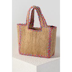 Carry your essentials in style this summer with this Natural Liv Tote. This classic woven jute bag features double handles and a vibrant pink and blue braided outline. This elegant pop of color will match with any outfit, and its large size is perfect for whatever warm weather activities you have in store. Details • Made in India • Dimensions: 11.5 x 6 x 10 in (29.2 x 15.2 x 25.4 cm) Trendy Braided Jute Beach Bag, Multicolor Jute Crochet Bag For Shopping, Multicolor Jute Straw Bag For Shopping, Spring Braided Jute Beach Bag, Blue Jute Bags For Summer, Spring Jute Beach Bag With Double Handle, Multicolor Jute Bag With Braided Handles, Multicolor Straw Bag For Spring, Casual Multicolor Double Handle Straw Bag